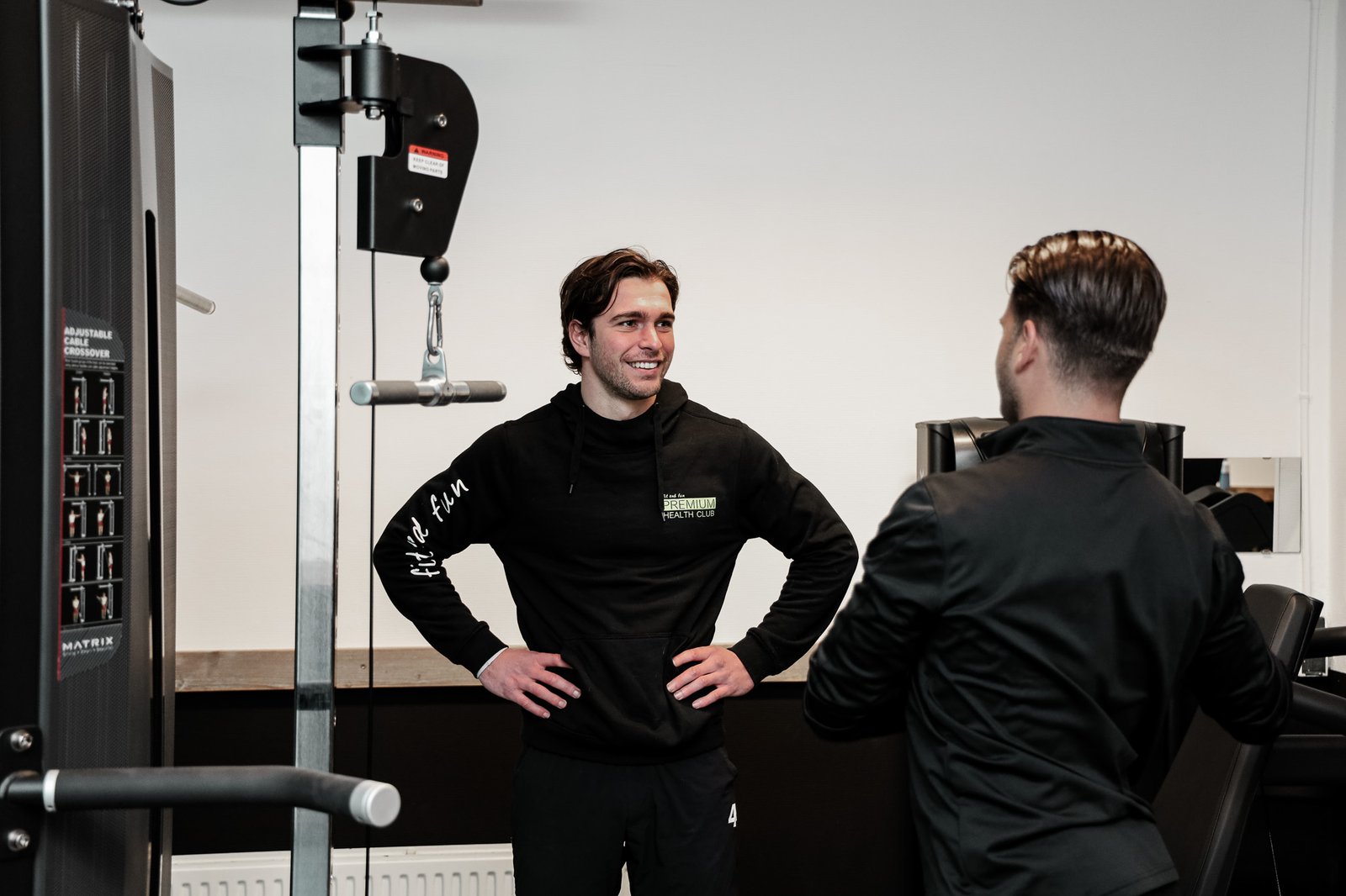 Coach van Premium Health Club begeleidt een sporter